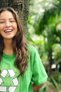 young volunteer: environmentalist  in the forest wearing a green recycling t-shirt